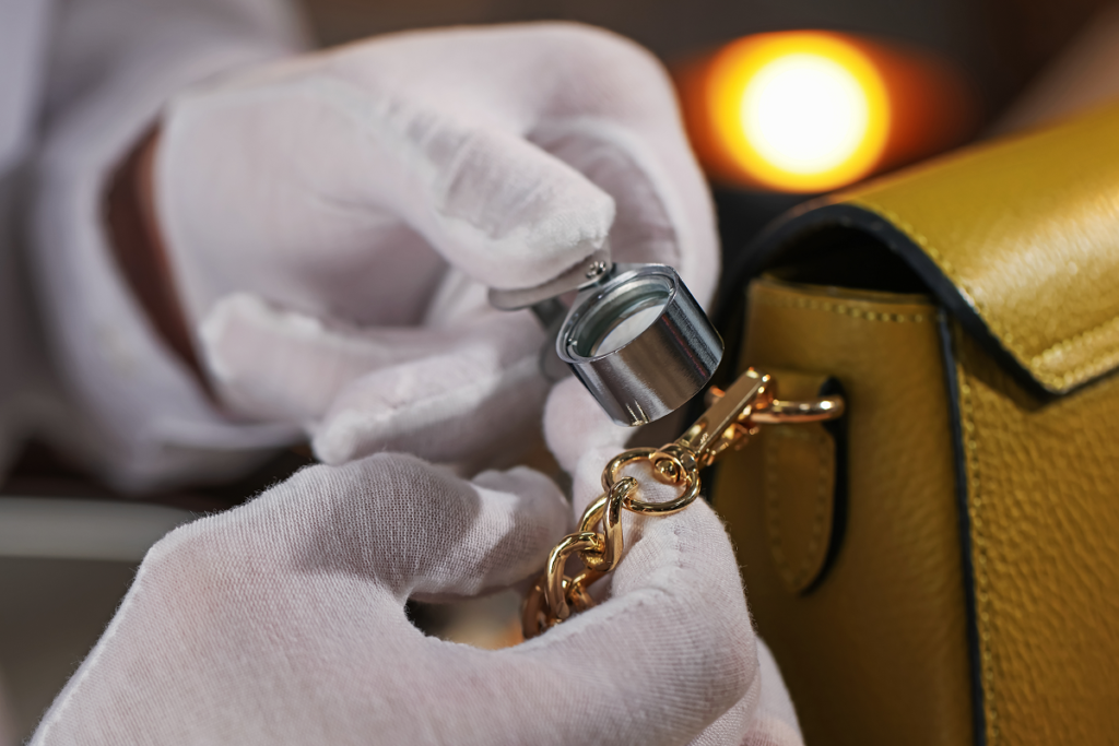 Appraiser inspecting a designer handbag before making a cash offer